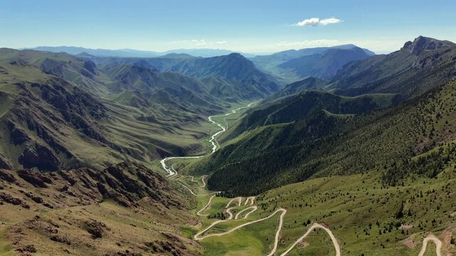 Scenic winding mountain road descending through Terskey-Torpok Pass, known as 33 Parrots Pass, on the route to Song-Kul in Kyrgyzstan