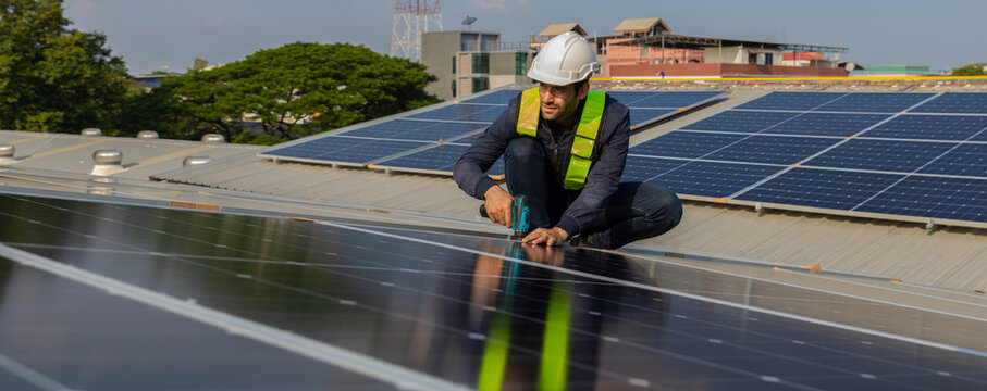 Engineer service check installation solar cell on the roof of factory. Engineers walking on roof inspect and check solar cell panel. Engineer working inspection installation solar cell on the roof