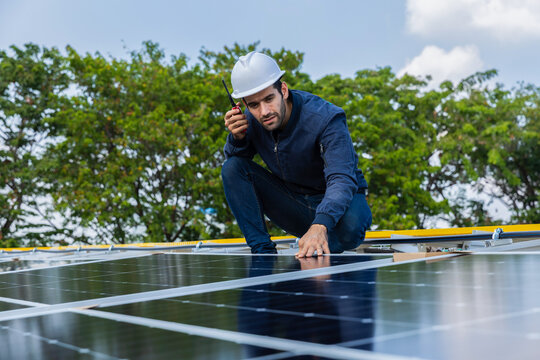Engineer service check installation solar cell on the roof of factory. Engineers walking on roof inspect and check solar cell panel. Engineer working inspection installation solar cell on the roof
