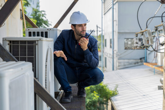 Air conditioner repairman, technician checking air conditioner, measuring device for refilling air conditioner. HVAC service technician using gauges to check refrigerant and add refrigerant.