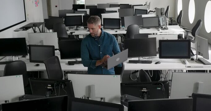 One Mature Male IT Professional in Modern Office working with Technology