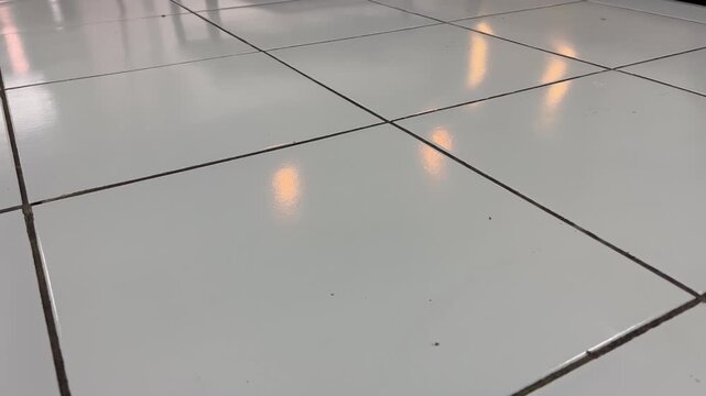 Glossy White Floor Tiles with Row of Light Reflections