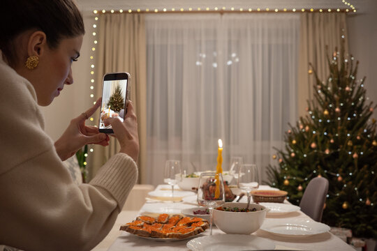 Woman Taking Photo of Christmas Dinner Table with Smartphone