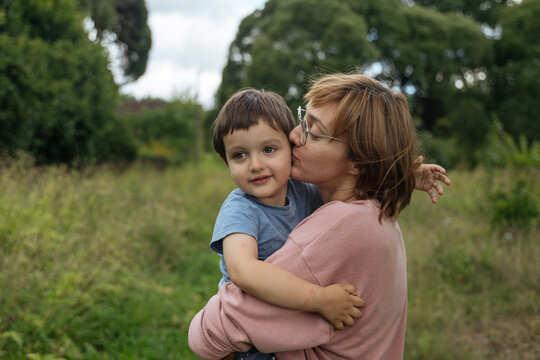 Mother kissing son outdoors