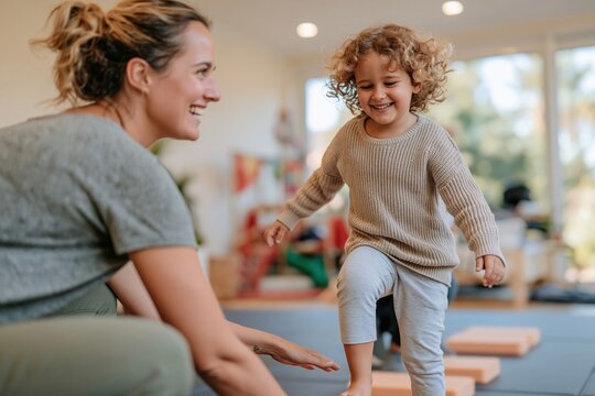Child stepping on soft foam blocks with a supportive woman in a luminous therapy room, for pediatric rehabilitation and motor development