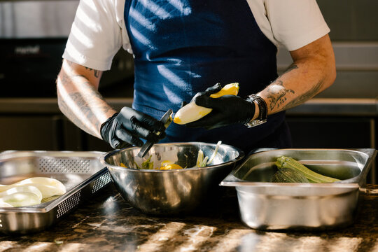 Chef meticulously peeling organic pumpkins in luxury kitchen.