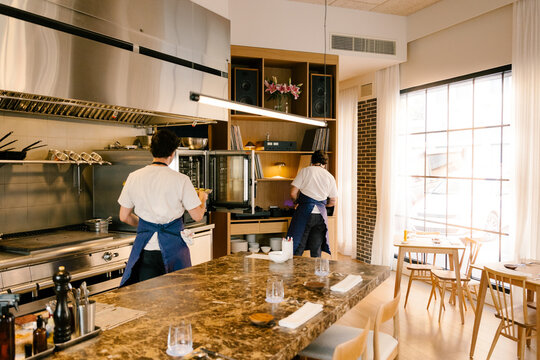 Workers setting up the dining room of a modern luxury restaurant