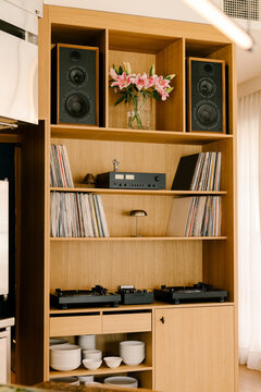 Long shot of a wooden restaurant shelf with vinyls and turntables.