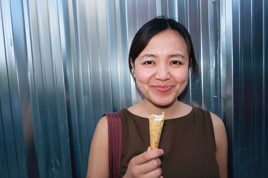 Woman enjoying refreshing ice cream cone in summer