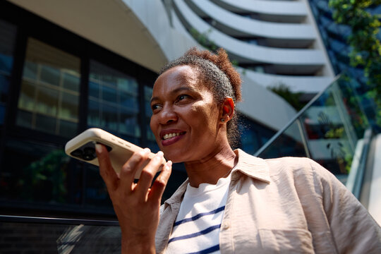 Woman sends voice messages via her phone in the city