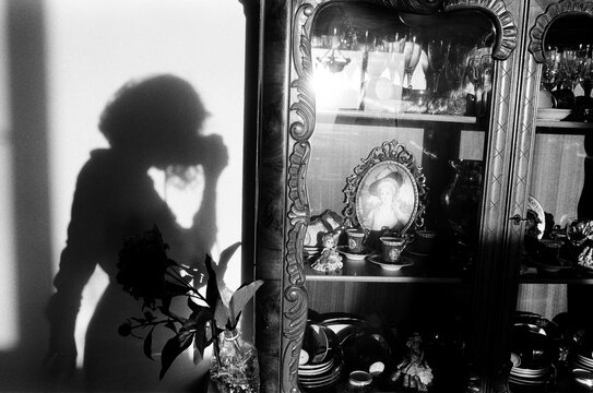 An Anonymous Woman Is Taking A Photo Of Her Shadow On The Wall