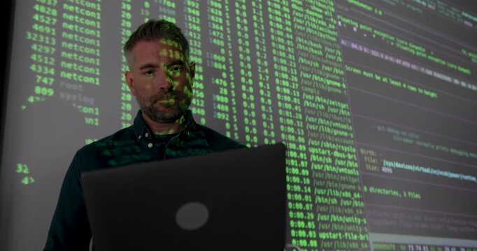 Mature Male Technology Expert Presenting Data Analysis on Screen, using Laptop