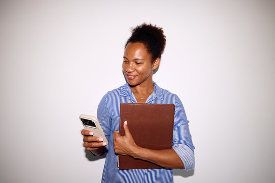 Portrait of a woman in a stripped shirt holding her files