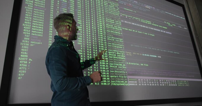 Mature Male Technology Expert Teaching Coding on Projection Screen