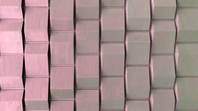 Abstract geometric 3D concrete block wall pattern in pastel pink