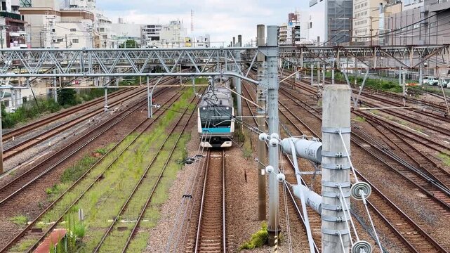 Keihin-Tohoku Line commuter train advancing through the dense rail network near Tsurumi Station, Yokohama