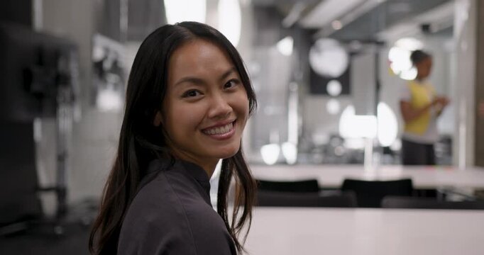 Portrait of Smiling woman in modern workspace setting, Looking at camera