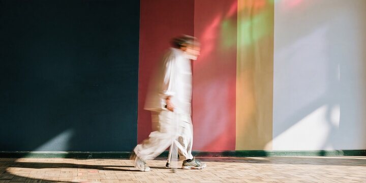 Color-blocked wall in a synagogue interior with a blurred man walking for simchat torah and jewish holiday celebrations, featuring copy space