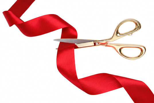 Gold scissors cutting a flowing red satin ribbon during a grand opening ceremony