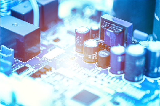 Close-up of electronic capacitors and components mounted on a printed circuit board with glowing light effects. Electronics engineering and hardware technology concept.