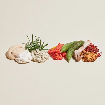 Three groups of food ingredients arranged in a line on a light beige surface, featuring creamy textures and pickled vegetables for culinary branding and copy space