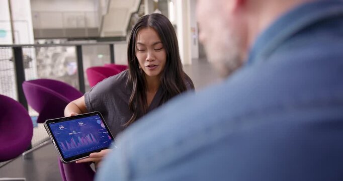 Business Meeting with Colleagues  in Open Plan Modern Office, using Digital tablet