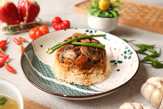 A plate of nasi tim jamur (steamed rice with stir-fried mushrooms), a complete meal that combines carbohydrates and protein in one dish, making it an ideal breakfast choice.