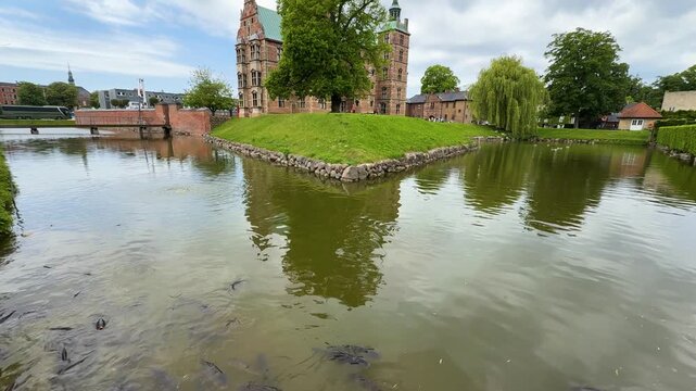 Fish swimming in moat around historic Rosenborg Castle in Copenhagen, Denmark