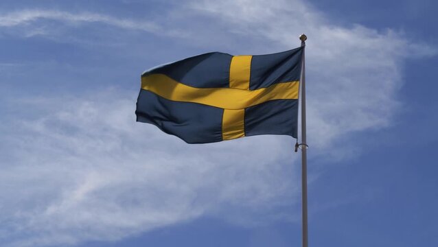 Close-up of national flag of Sweden waving against clear blue sky