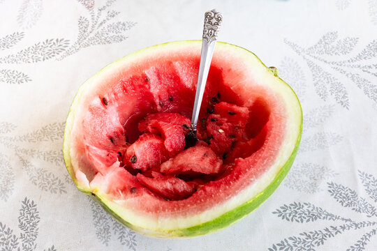 half fresh watermelon with tablespoon on table