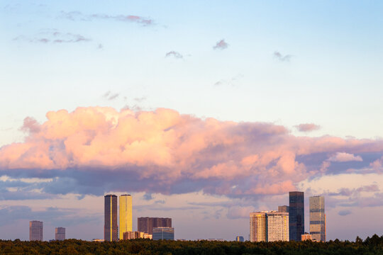 pink cloud in blue sunset sky over modern building