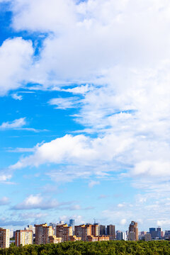 blue sky with large white cloud over city district
