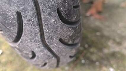 Extreme close-up of a textured black motorcycle tire showing detailed tread patterns, grooves, and surface texture © arifiandi