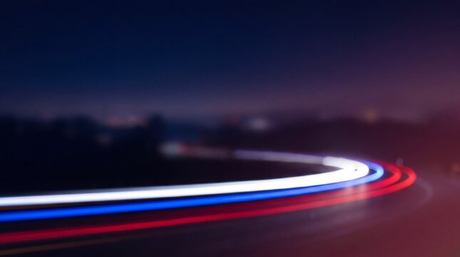 Long exposure light trails of red and white car headlights on a dark highway at night