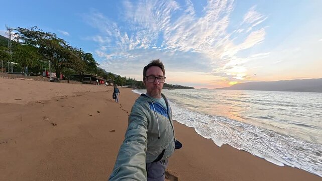 Happy Man Taking a Selfie on a Tropical Beach at Sunset in Ilhabela, Brazil