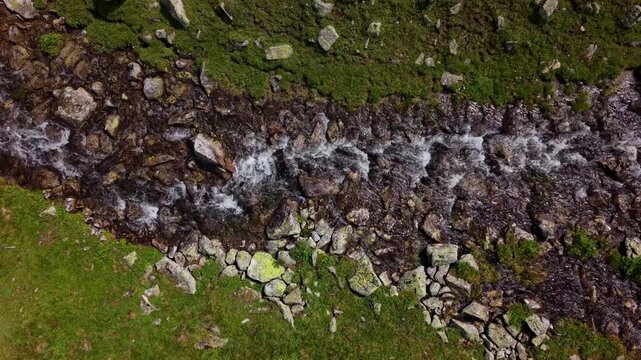 Aerial view of mountain stream flowing over rocks