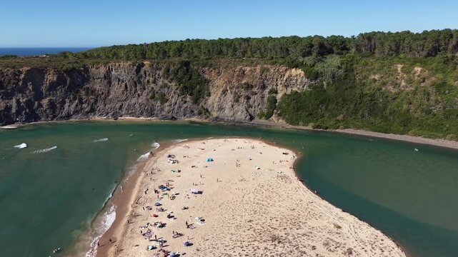 People sunbathing at odeceixe beach in portugal