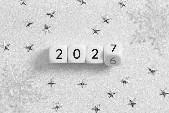 2026 changing to 2027 on dice with christmas glitter silver background for new year change concept