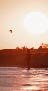 Silhouette on person shallow ocean water at sunset on a sandy beach