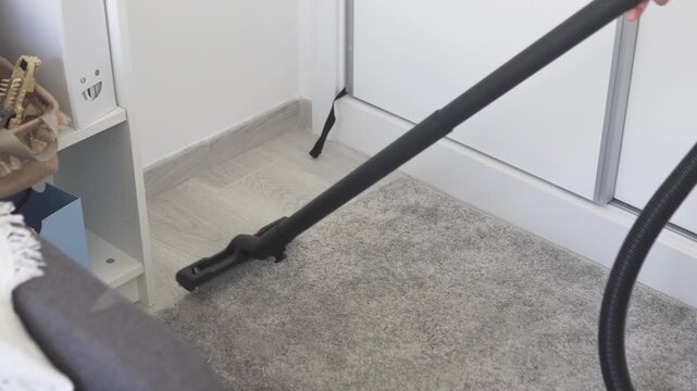 Cleaning dust in an apartment with a vacuum cleaner, home cleaning and household chores concept