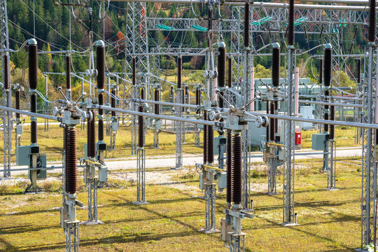 Am Wasserkraftwerk an der Isar bei Kr&uuml;n steht ein elektrisches Umspannwerk mit Transformatoren, Isolatoren und Stromleitungen.