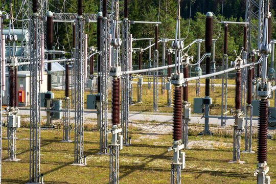 Am Wasserkraftwerk an der Isar bei Kr&uuml;n steht ein elektrisches Umspannwerk mit Transformatoren, Isolatoren und Stromleitungen.