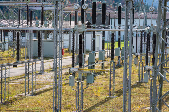 Am Wasserkraftwerk an der Isar bei Kr&uuml;n steht ein elektrisches Umspannwerk mit Transformatoren, Isolatoren und Stromleitungen.