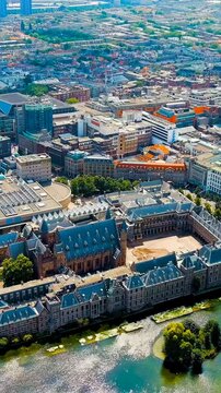 Vertical video. The Hague, Netherlands. Binnenhof. Hofvijver lake in the historical city center. Cloudy weather. Summer day. Drone footage, Point of interest. Rich colors