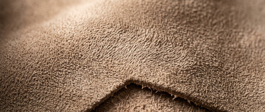 Close-up of soft brown suede fabric texture with seam detail  