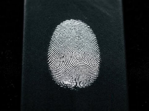 Detailed Fingerprint Imprint on Black Textured Surface Close Up Macro Shot