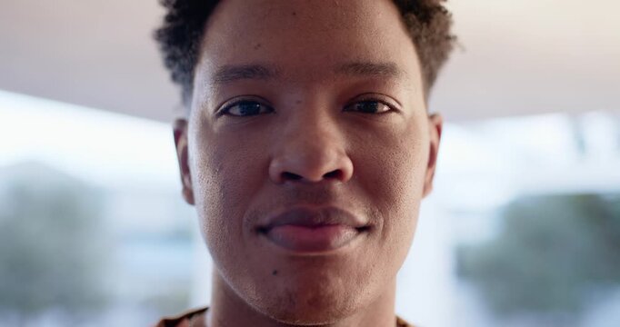 African American man wearing print top smiling, laughing while responding to camera at home window