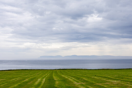 Ocean View with Grass Field and Cloudy Sky in Thurso, Scotland, UK.