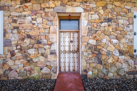 Rustic stone house facade with wooden entrance door