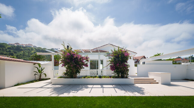 White house with landscaped garden and sunny patio
